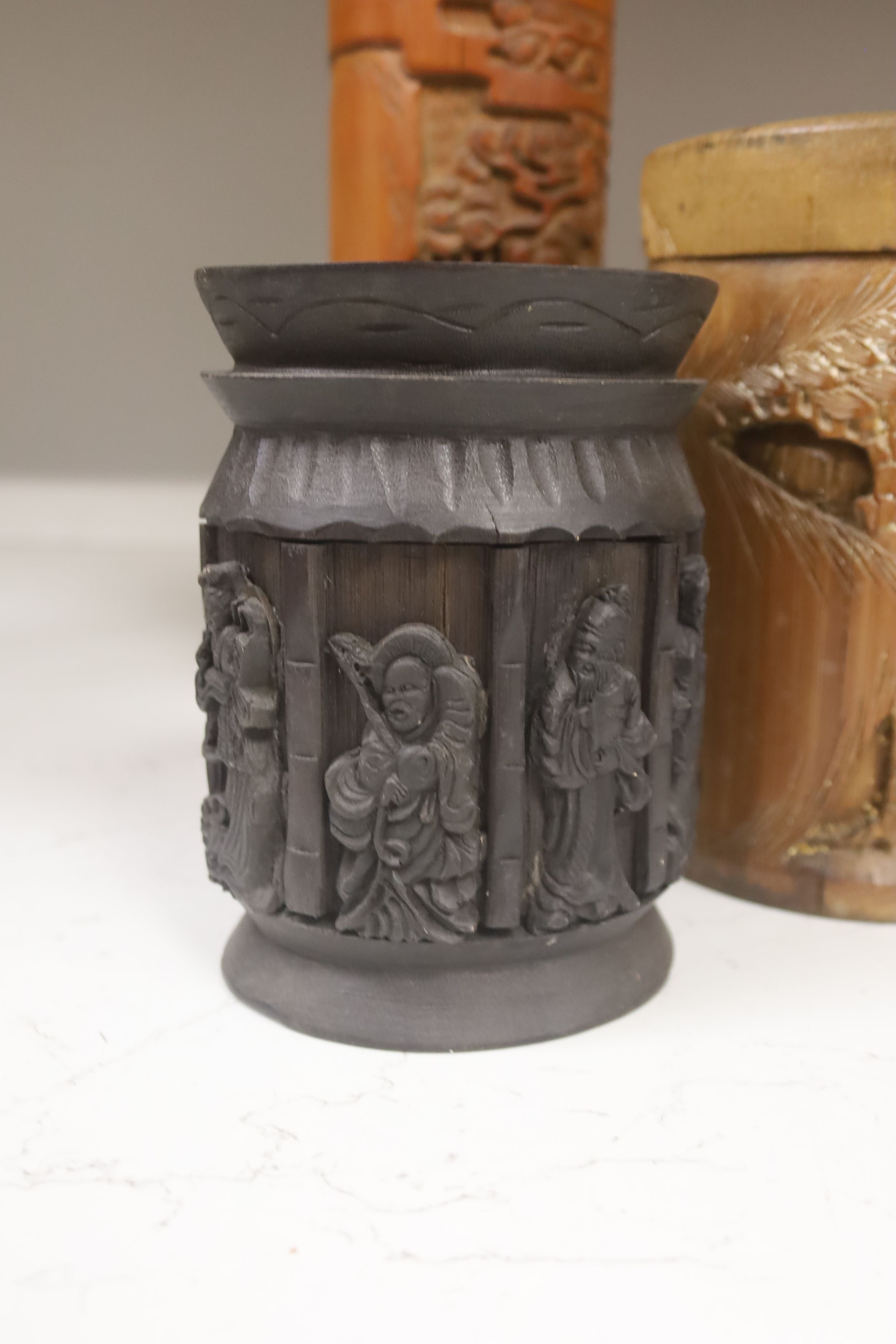 Three Chinese carved bamboo tea caddies and four carved bamboo brush pots